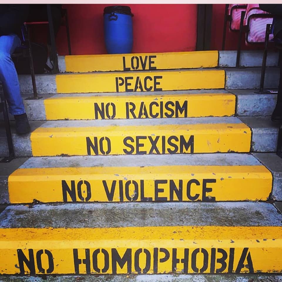 Whitehawks FC signage on the steps in the stand: Love, Peace, No Racism, No Sexism, No Violence, No Homophobia